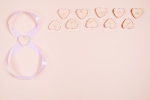 March 8, composition of hearts on a pink background. View from above. Space for text, flat lay