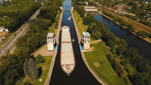 Sluice Gates on the River. Aerial view barge, ship in the river gateway. River sluice construction, water river gateway. Shipping channel.