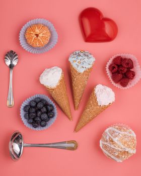 ice cream, blueberries, raspberry, tangerine, muffin and red heart on pink background