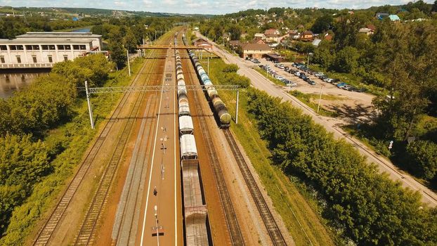 Freight train with cisterns and containers on the railway. Aerial view Container Freight Train, Locomotive in the countryside, Railway and highway.
