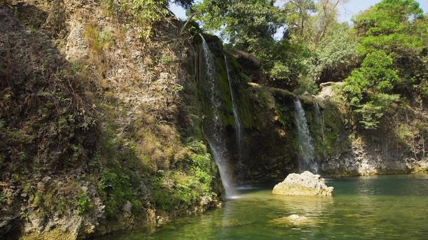 Waterfall in green rainforest. Bolinao waterfall in the mountain jungle. Philippines, Luzon. Travel concept.