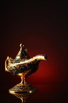 A magical ornate brass oil lamp over an atmospheric red and black gradient background.