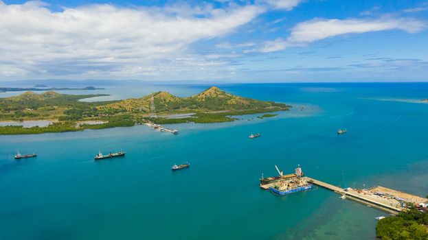 Aerial view of cargo ships leaving sea harbour at sunny day, islands on background. Tapal Wharf, Bohol, Philippines.