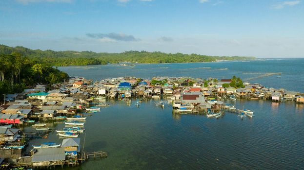 Village of fishermen with houses on the water, with fishing boats. Fishing village with wooden houses on stilts in the sea. Philippines, Mindanao.