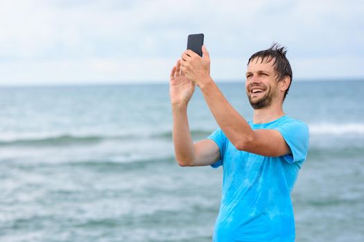 A man communicates via video communication using a mobile phone while relaxing on the sea