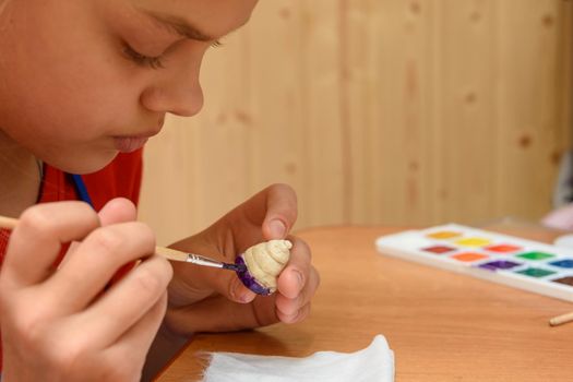 Girl at home paints figures from salt dough