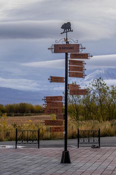 A pole with a direction indicator on the background of volcanoes in Kamchatka. Travel to Russia