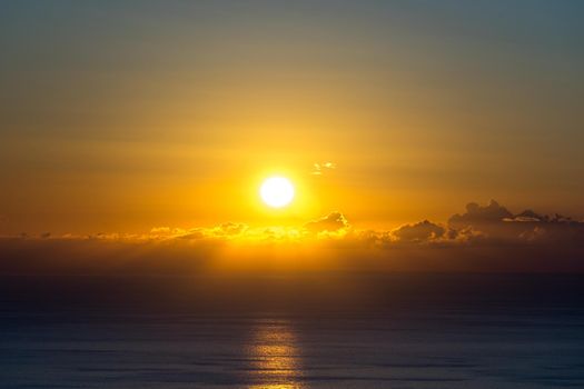 bright sunset over the sea from a height on a background of sea and sky with clouds