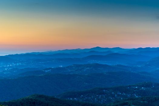 Sochi, Russia. Mountain landscape with several rows of hills at sunset.