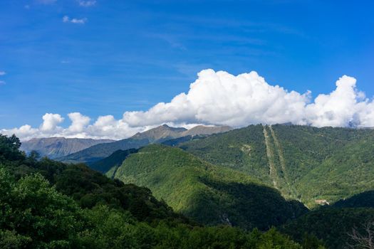 Beautiful mountain landscape on blue sky background with clouds.