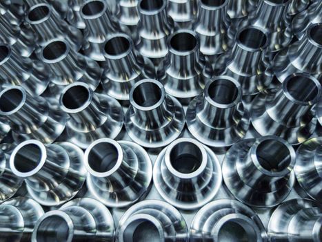 a batch of shiny steel cnc aerospace parts production - close-up with selective focus for industrial background.