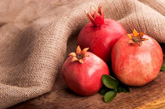 Pomegranate on wooden boards and simple fabric