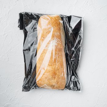 Ciabatta panini bread in a plastic bag, on white background, top view flat lay