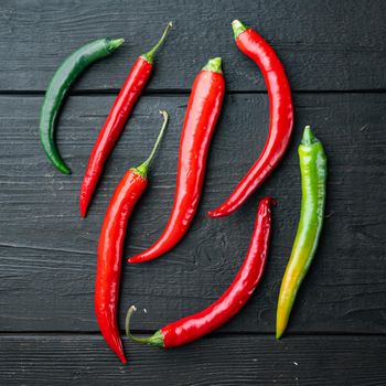 Ripe Red and green chili pepper set, on black wooden table background, top view flat lay