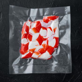 Crab fish meat in vacuum pack set, on black background, top view flat lay