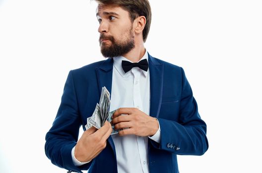 rich gentleman in blue jacket bow tie shirt money pack currency. High quality photo