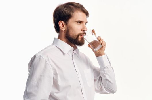 portrait of a man with a glass of water drink cooling light background shirt model. High quality photo