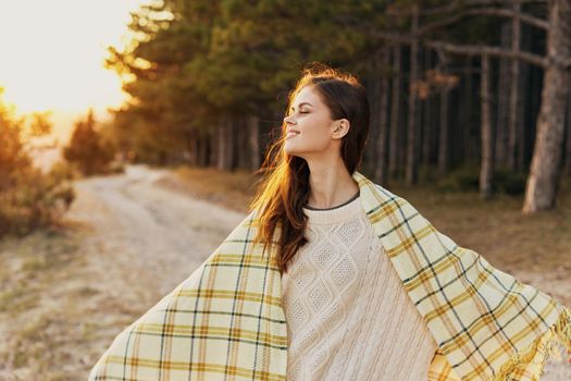 woman spreads her hands to the sides in nature near coniferous trees. High quality photo