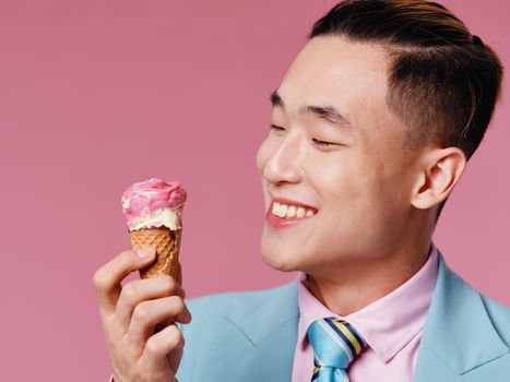 Happy guy in a classic suit and ice cream in a cone pink background. High quality photo