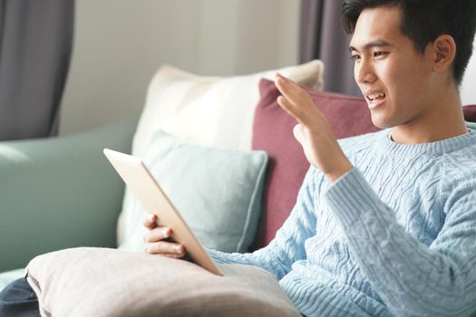 asian young teenage student man teenager entrepreneur working with tablet studying learning online at home. e-learning webinar meeting. social distance in covid pandemic