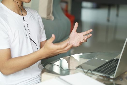 asian young teenage student man entrepreneur wear headphones working by video call conference studying learning online at home. e-learning webinar meeting. social distance in covid pandemic