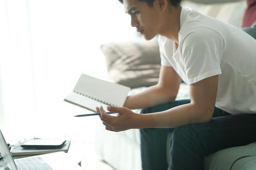 asian young teenage student man teenager entrepreneur working with computer studying learning online at home. e-learning webinar meeting. social distance in covid pandemic