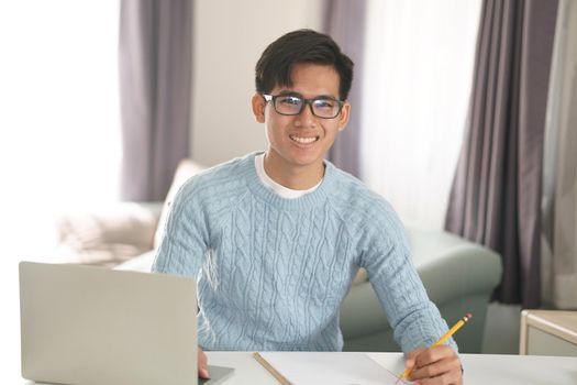 asian young teenage student man teenager entrepreneur working with computer studying learning online at home. e-learning webinar meeting. social distance in covid pandemic