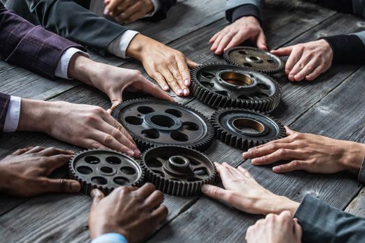 Business people connect gear together at meeting table, success cooperation teamwork concept