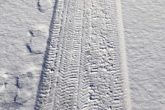 Tire Tracks on snow covered streets in a close up view