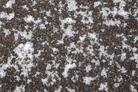 Dirty tracks of snow on asphalt on a small german road.