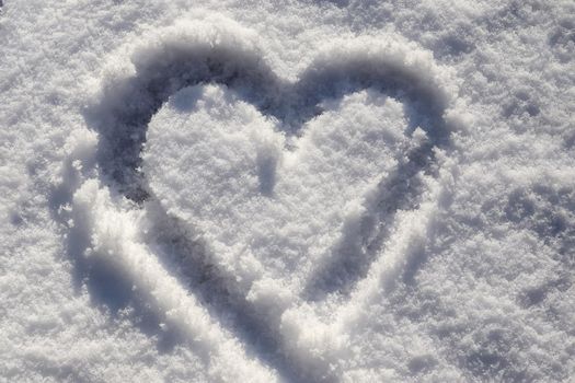 Sunny fresh snow texture with drawn valentine heart symbol.