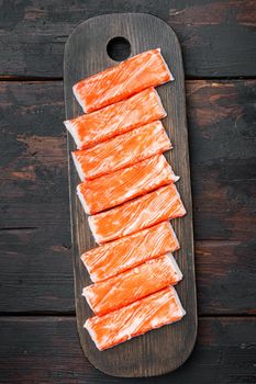 Fresh Crab meat stick surimi set, on wooden cutting board, on dark wooden background