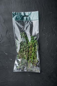 Fresh juicy Thyme in market pack set, on black background, top view flat lay