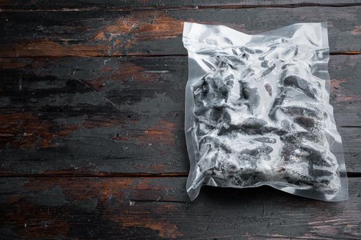 Vacuum packed whole shell mussels frozen, on dark wooden background , with copyspace and space for text