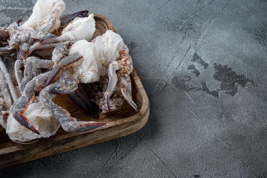 Frozen raw blue swimming crab meat set, on wooden tray, on gray background , with copyspace and space for text