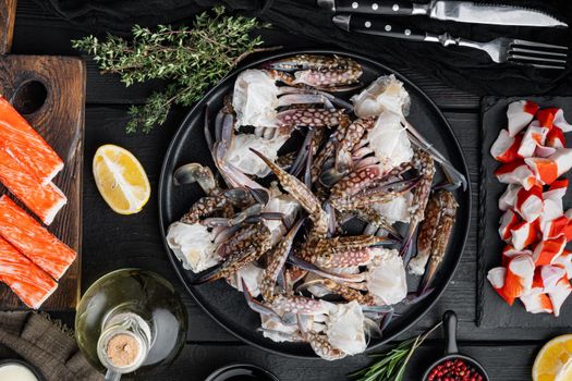 Fresh Crab meat and sticks surimi with blue swimming crab set, on black wooden table background, top view flat lay