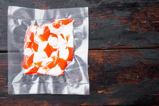 Crab fish meat in vacuum pack set, on dark wooden background, top view flat lay , with copyspace and space for text