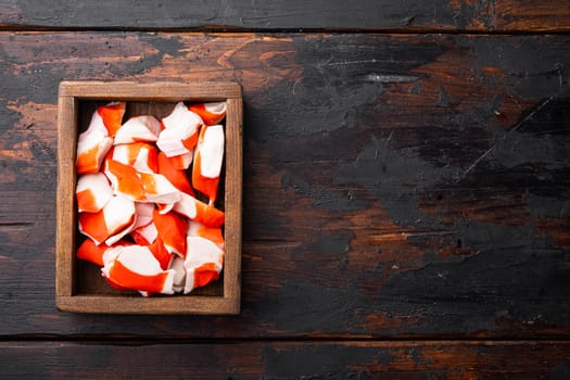 Asian snack surimi set, in wooden box, on dark wooden background, top view flat lay , with copyspace and space for text