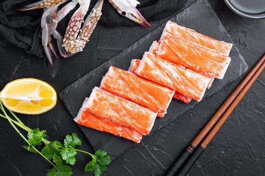 Fresh Crab meat stick surimi with blue swimming crab set, on stone board, on black background