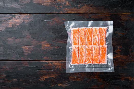 Crab stick surimi vacuum pack set, on dark wooden background, top view flat lay , with copyspace and space for text