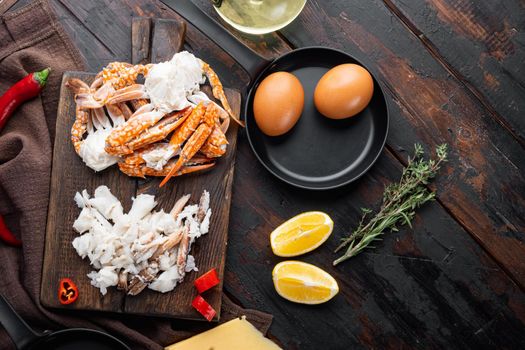 Ingredients for breakfast omelette with crab meat and cheese set, on dark wooden background, top view flat lay