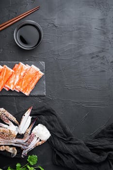 Fresh Crab meat stick surimi with blue swimming crab set, on stone board, on black background, top view flat lay , with copyspace and space for text