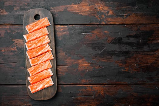 Asian snack surimi set, on wooden cutting board, on dark wooden background, top view flat lay , with copyspace and space for text