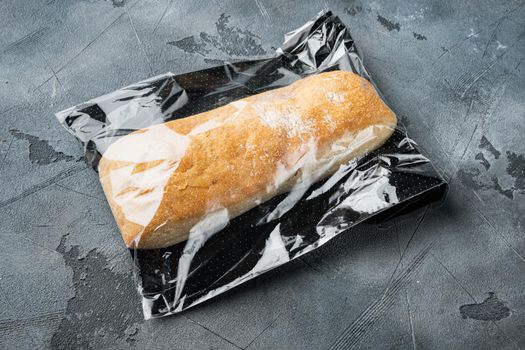 Loaf of fresh baked artisan whole grain ciabatta bread in a market bag, on gray background