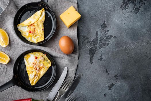 Thai Asian omelette, fresh red chilli, brown and white crabmeat, lemon, Cheddar cheese and eggs, on frying iron pan, on gray background, top view flat lay , with copyspace and space for text