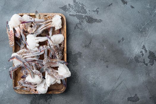 Frozen raw blue swimming crab meat set, on wooden tray, on gray background, top view flat lay , with copyspace and space for text