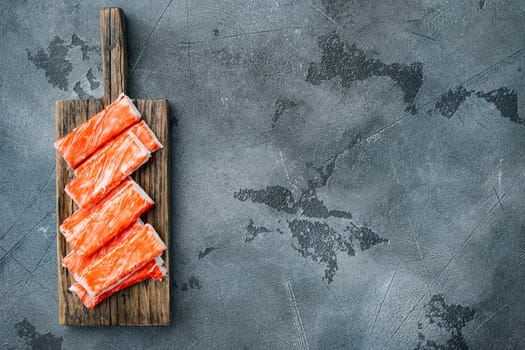 Asian snack surimi set, on wooden cutting board, on gray background, top view flat lay , with copyspace and space for text