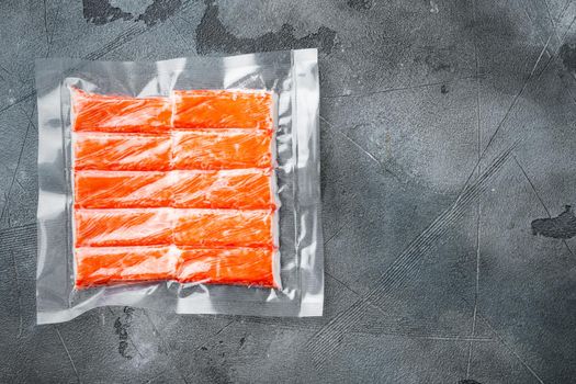 Crab stick surimi vacuum pack set, on gray background, top view flat lay , with copyspace and space for text