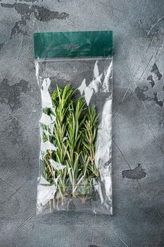 Rosemary in plastic bag set, on gray background, top view flat lay