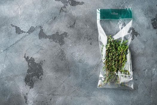 Thyme in plastic bag set, on gray background, top view flat lay , with copyspace and space for text